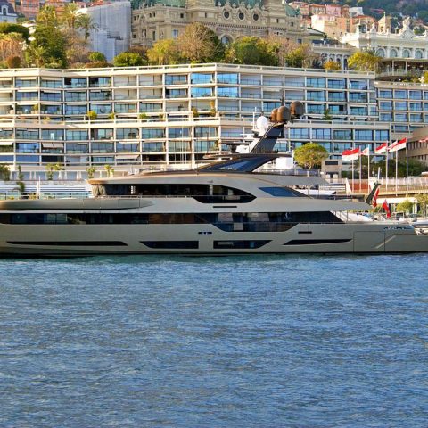 Luxury superyacht docked at Monaco harbor, available to charter with a deposit